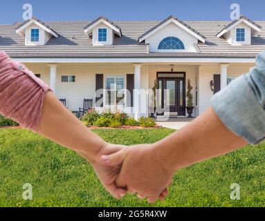 Couple tenant les mains approchant de la porte avant de la nouvelle maison. Banque D'Images