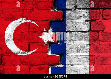 Concept de la relation entre la Turquie et la France avec deux drapeaux peints sur un mur de briques endommagé Banque D'Images