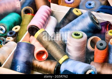 Variété de fils de couture colorés à la fenêtre d'exposition d'un magasin de tailleur. Banque D'Images