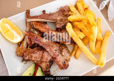 Côtelettes d'agneau grillées servies avec des frites au restaurant. Cuisine grecque traditionnelle. Banque D'Images