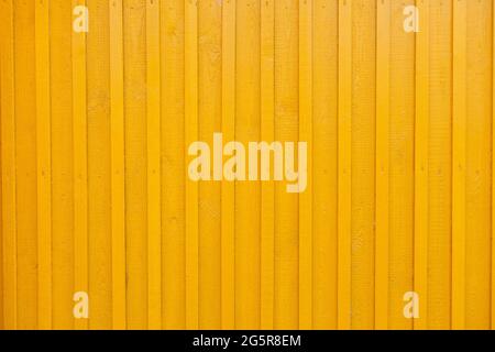 Panneau en bois jaune mur texturé arrière-plan. Le mur de la maison en bois est peint en jaune. Peint en jaune vertical mur de rendu en bois. wa Banque D'Images