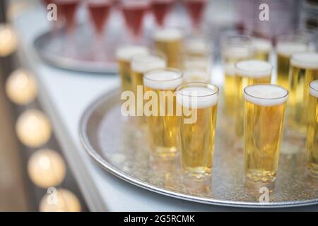 Champagne et vin en petits flûtes sur les plateaux de service lors d'une fête formelle Banque D'Images