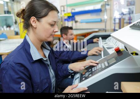 Femme à l'aide d'un panneau de commande à l'usine Banque D'Images