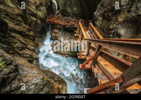 Sentier de randonnée en bois à l'intérieur d'une gorge avec rivière de montagne bue, Sigmund Thun Klamm, Kaprun, Autriche. Banque D'Images