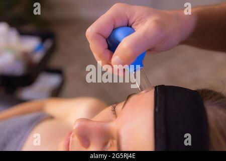 Femme reçoit de rajeunissement du visage massage du visage saigner à l'acupuncture wellness spa Banque D'Images