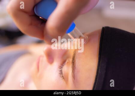 Femme reçoit de rajeunissement du visage massage du visage saigner à l'acupuncture wellness spa Banque D'Images