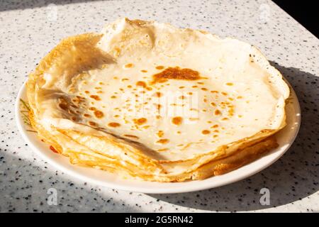 Grandes crêpes rondes sur une assiette sur la table Banque D'Images