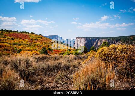 Les couleurs vives de l'automne encadrent le mur peint lointain tandis que les randonneurs marchent le long de la route du plateau nord jusqu'au point d'exclamation Banque D'Images