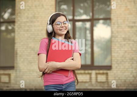 Les filles méritent le monde. Obtenez des connaissances de ebook. Éducation scolaire moderne. Retour à l'école. Heureux adolescent porte le classeur. Souriant enfant tient des dossiers Banque D'Images