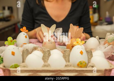 Le processus de teinture des oeufs en peaux d'oignon. Coloration écologique des oeufs pour Pâques. Une femme prépare des œufs pour la peinture. Banque D'Images