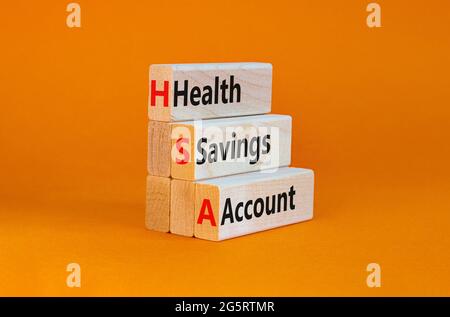 Symbole du compte d'épargne santé HSA. Mots-clés compte d'épargne santé HSA sur des blocs de bois sur un beau fond orange. Entreprise et santé HSA Banque D'Images