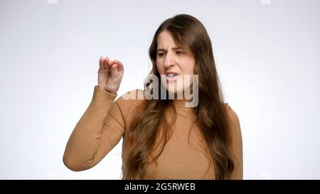 Jeune femme sceptique faisant le geste de blah avec la main. Banque D'Images