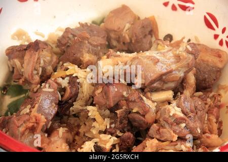 Délicieux morceaux de viande d'agneau cuite et frite de pilaf avec du riz dans une tasse de gros plan, cuisine Banque D'Images