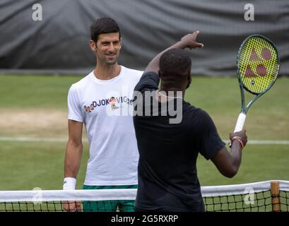 Novak Djokovic pratique avec Frances Tiafoe sur les courts de pratique d'Aorangi le deuxième jour de Wimbledon au All England Lawn tennis and Croquet Club, Wimbledon. Date de la photo: Mardi 29 juin 2021. Banque D'Images