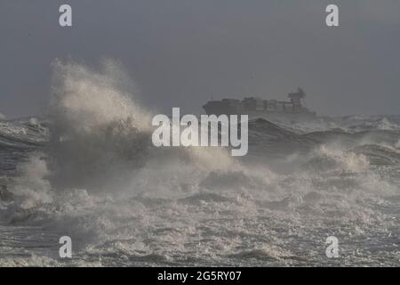 Navire-conteneur traversant la côte portugaise par une journée de tempête. MISE AU POINT AU PREMIER PLAN. Banque D'Images