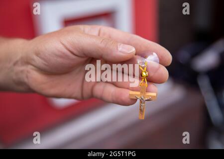 Croix en bois consacrée dans l'église. La main tient une suspension en croix. Croix sur la ventouse de suspension dans la voiture Banque D'Images