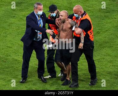 Un envahisseur de terrain est enlevé par la sécurité lors du match de l'UEFA Euro 2020 Round de 16 à Hampden Park, Glasgow. Date de la photo: Mardi 29 juin 2021. Banque D'Images