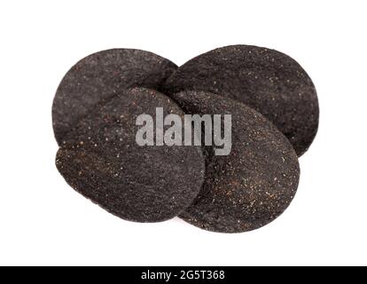 Chips de pomme de terre noires isolées sur fond blanc. Chips noires avec charbon actif et poivre rouge. Banque D'Images