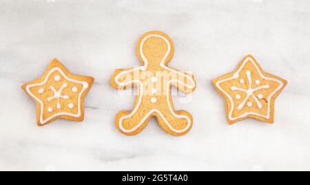 Trois biscuits au pain d'épice dans une rangée sur un comptoir en marbre Banque D'Images