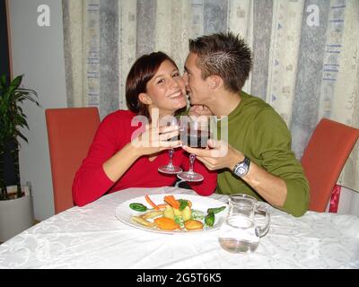 jeune couple amoureux assis à une table avec un hors-d'œuvre pour deux et boire un verre de vin rouge ensemble Banque D'Images