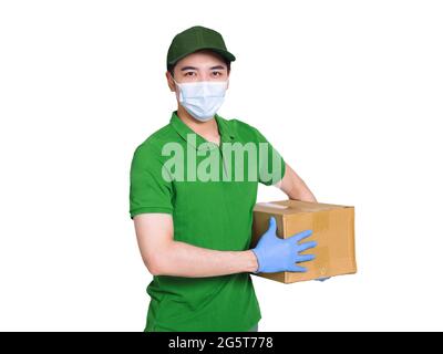 Le jeune messager porte des masques médicaux et des gants pour se protéger pendant le travail de l'épidémie de Covid-19, et tient des paquets de carton dans ses mains Banque D'Images