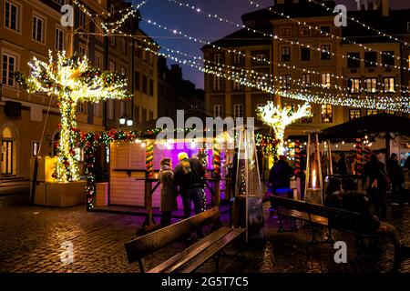 Varsovie, Pologne - 19 décembre 2019 : place du marché de la vieille ville Varsovie la nuit et le nouvel an illuminations arbres décorations personnes Banque D'Images