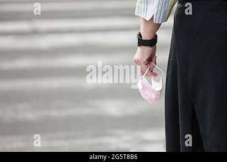 Photo des mains d'une jeune femme tenant un masque rose, fait pour les femmes, dans une rue de Belgrade, Serbie, pendant le coronavirus Covid 2020 2021 19 Banque D'Images