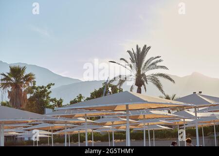 Vue sur les montagnes, les palmiers et la plage au coucher du soleil. Mer Méditerranée. Papier peint ou imprimé été. Photo de haute qualité Banque D'Images