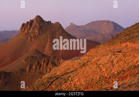 ALGÉRIE. HOGGAR.TAMANRASSET. LE PÈRE CHARLES DE FOUCAULD BUIT SON ERMITAGE AU SOMMET DE LA MONTAGNE ASSEKREM À 2780M D'ALTITUDE EN 1911 FACE À UN I Banque D'Images