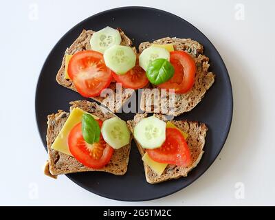 pain sans gluten coupé et cuit au four avec fromage, concombre, tomate et basilic Banque D'Images