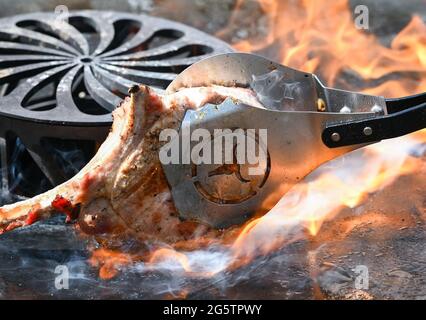 21 juin 2021, Brandebourg, Lübben : un morceau de chop (côtelettes de porc) est cuit sur un grill. Photo: Patrick Pleul/dpa-Zentralbild/ZB Banque D'Images