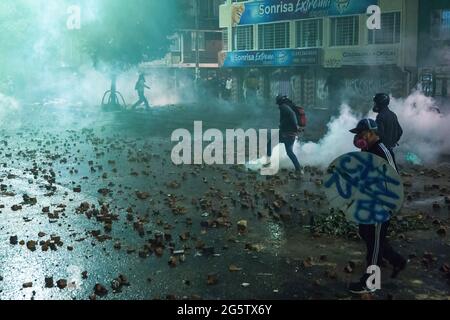 Bogota, Colombie. 27 juin 2021. Des membres de la ligne de front sont vus pendant la confrontation avec la police anti-émeute. Le 28 juin a marqué deux mois de manifestations en Colombie. Dans de nombreuses villes du pays, des blocus et des manifestations ont eu lieu. En réponse, le gouvernement a déployé une police anti-émeute, déclenchant des affrontements qui ont fait des centaines de manifestants blessés. Crédit : SOPA Images Limited/Alamy Live News Banque D'Images