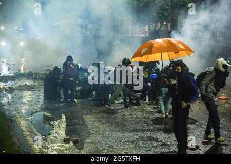 Bogota, Colombie. 27 juin 2021. Les membres de la première ligne affrontent la police anti-émeute pendant la manifestation.le 28 juin a marqué deux mois de manifestations en Colombie. Dans de nombreuses villes du pays, des blocus et des manifestations ont eu lieu. En réponse, le gouvernement a déployé une police anti-émeute, déclenchant des affrontements qui ont fait des centaines de manifestants blessés. Crédit : Antonio Cascio/SOPA Images/ZUMA Wire/Alay Live News Banque D'Images