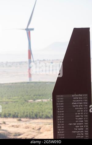 Golan Heights, Israël. Une plaque commémorative pour les soldats israéliens morts au combat lors de la guerre de Yom Kippour en 1973. Une éolienne en arrière-plan. Banque D'Images