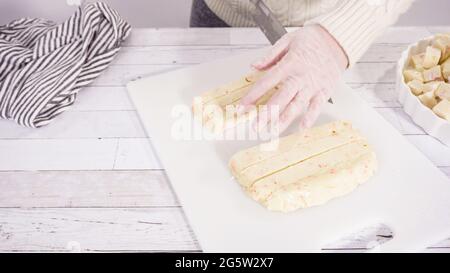 Étape par étape. Coupe de fudge de canne à sucre fait maison sur un tableau de découpe blanc. Banque D'Images