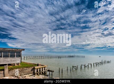 Jetée en ruines à la baie de Baffin, côte du golfe, bateau à distance, vue du hameau de Riviera Beach, près de Kingsville, Texas, États-Unis Banque D'Images