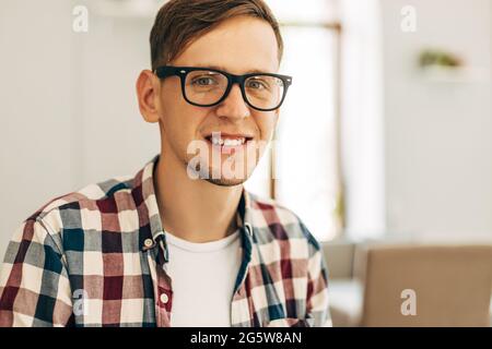 Un travailleur masculin attrayant utilise un ordinateur à la cafétéria, un jeune homme travaille à l'aide d'un ordinateur portable Banque D'Images