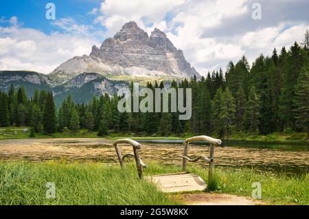 Un petit pont en bois en face du lac d'Antorno et le carillon des arbres en arrière-plan. dolomites en italie. Été Banque D'Images