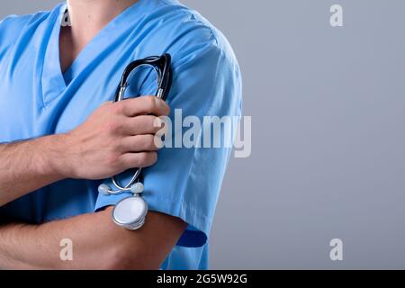 Section médiane du médecin caucasien portant un stéthoscope, isolé sur fond gris Banque D'Images