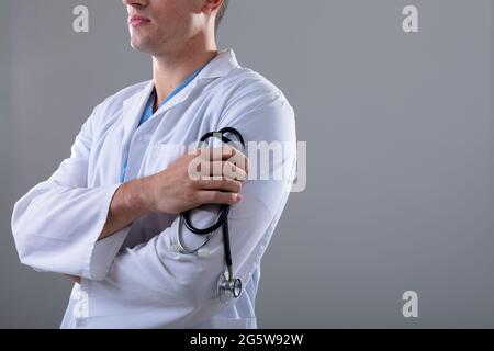 Section médiane du médecin caucasien portant un stéthoscope, isolé sur fond gris Banque D'Images