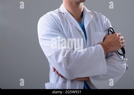 Section médiane du médecin caucasien portant un stéthoscope, isolé sur fond gris Banque D'Images