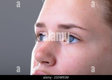 Gros plan des yeux bleus de la femme d'affaires caucasienne, isolée sur fond gris Banque D'Images