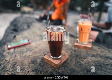 Café glacé dans un verre sur une table en bois dans un café. Banque D'Images