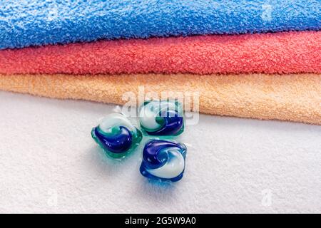 Dosettes de lessive pour lave-linge et serviettes de bain colorées. Capsule de gel écologique trois en une. Banque D'Images
