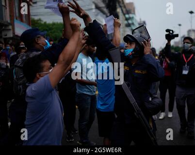 Katmandou, Népal. 30 juin 2021. Le personnel de police a arraché des pancartes contre le Premier ministre du Népal, KP Sharma Oli, lors d'une manifestation contre la dissolution du Parlement, le remaniement ministériel et les élections anticipées à Katmandou, au Népal, le mercredi 30 juin 2021. Crédit: Skanda Gautam/ZUMA Wire/Alay Live News Banque D'Images