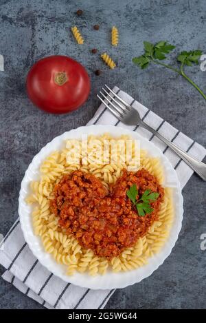 Ragoût de bolognaise, sauce au bœuf italien moulu avec pâtes Fusilli, prise verticale Banque D'Images