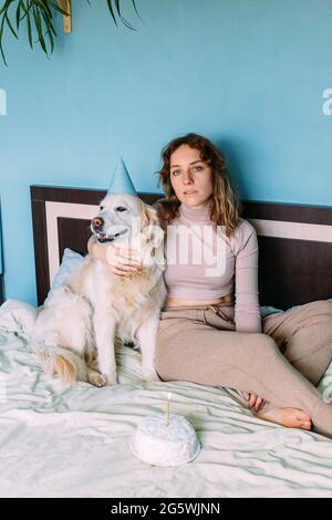 Le Chien Labrador Golden Retriever Fete Son Anniversaire En Casquette Et Avec Un Gateau Photo Stock Alamy