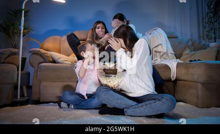 La grande famille a eu peur tout en regardant un film d'horreur effrayant ou une émission de télévision la nuit. Banque D'Images