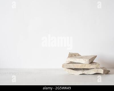 Podium en pierres naturelles grises sur fond blanc, plate-forme pour l'affichage des produits. Cache pour le design en forme de maquette. Vue avant. Copier l'espace Banque D'Images