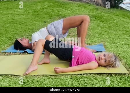 Bonne santé bonne famille maman et fille faisant des exercices d'étirement sur bord de mer Banque D'Images